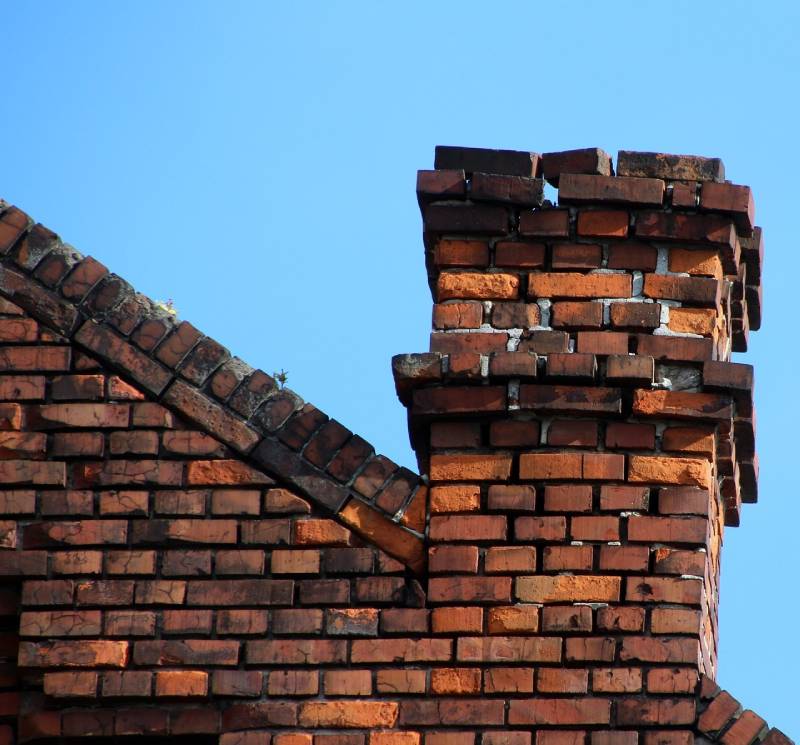 Damaged chimney on an Pontiac home showing cracks and missing mortar